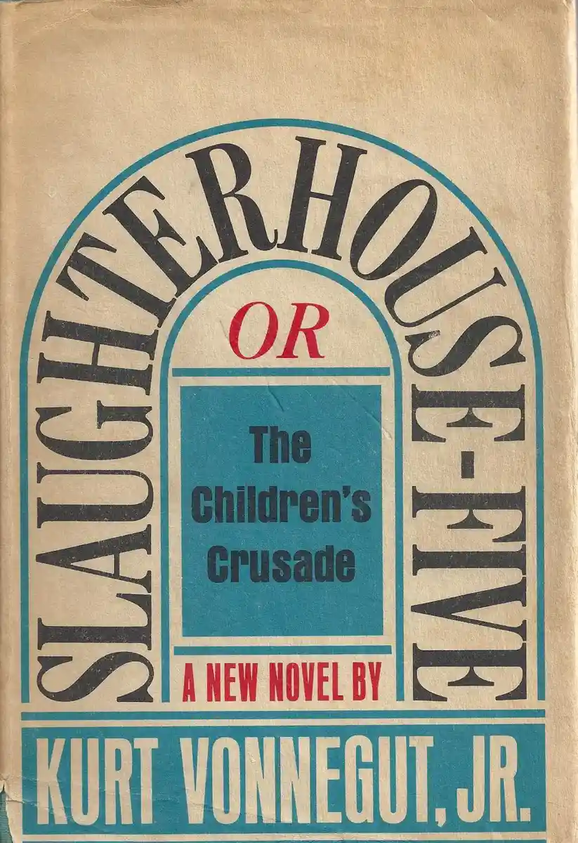 The image shows the cover of Kurt Vonnegut's novel 'Slaughterhouse-Five or The Children's Crusade'. The title is arched in…
