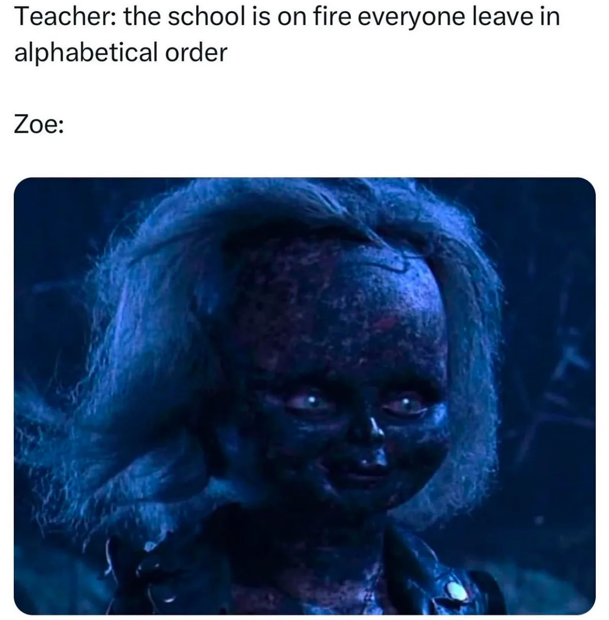 The image shows a close-up of a dirty, doll-like figure with pale skin, wild hair, and a sinister grin, set against a dark…