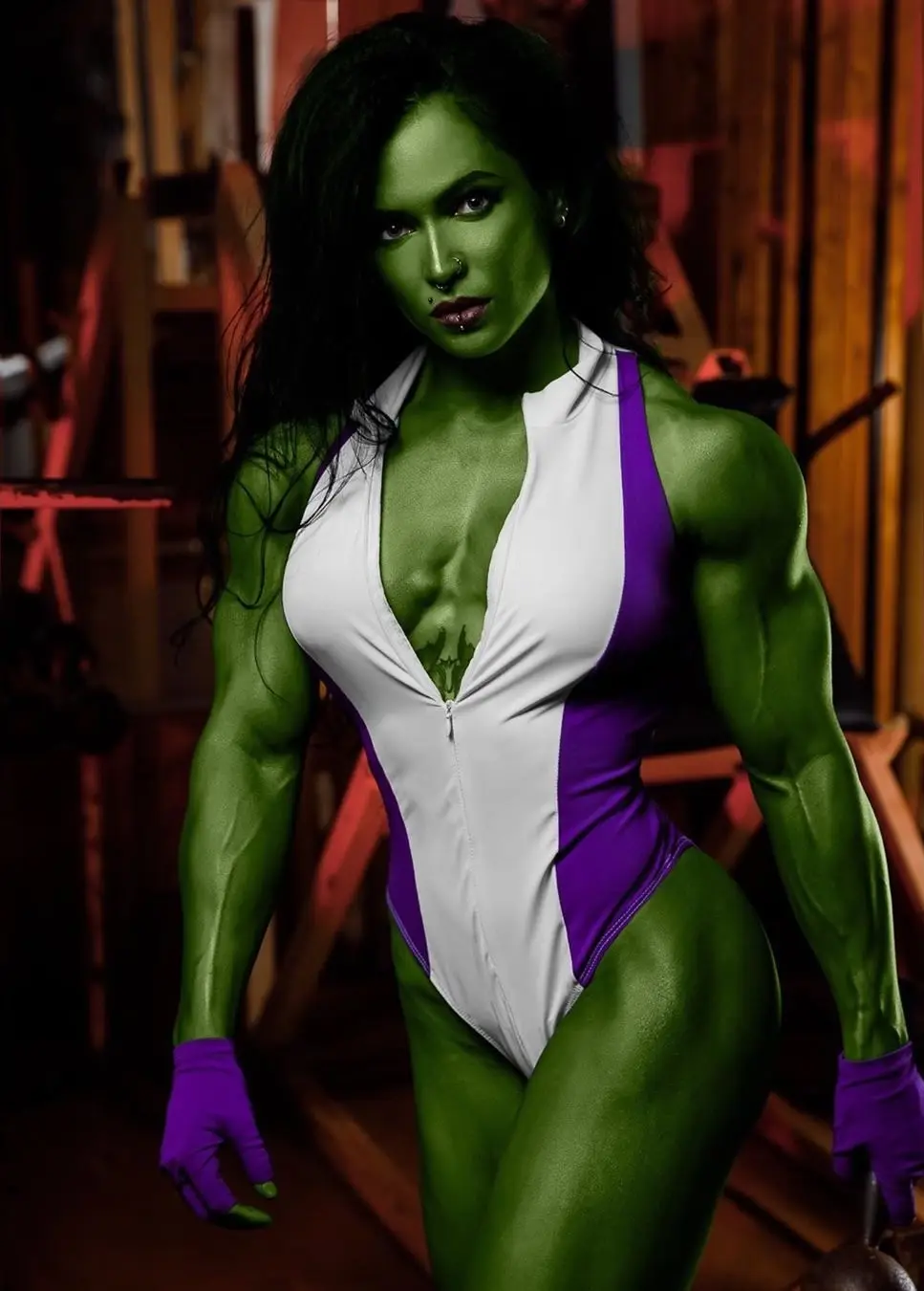 A muscular woman with green skin, black hair, and a nose piercing poses confidently in a white and purple one-piece athletic…