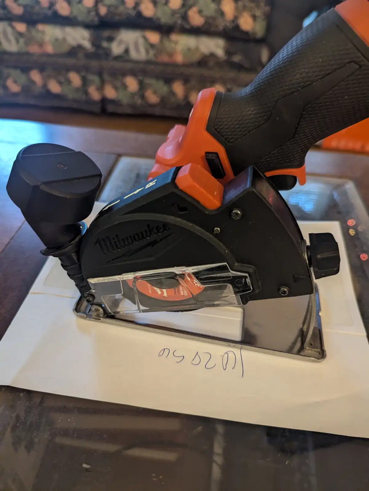 A Milwaukee brand circular saw rests on a piece of paper with the handwritten text 'i'm not a tool, i'm a tool' written on…