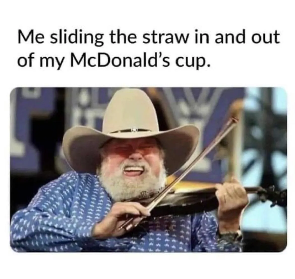 A man with a white beard and cowboy hat is playing a violin with intense, joyful expression. The overlaid text reads 'Me…