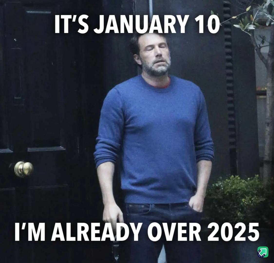 A man with a weary expression stands in front of a dark door, wearing a blue sweater and jeans. White bold text overlays the…