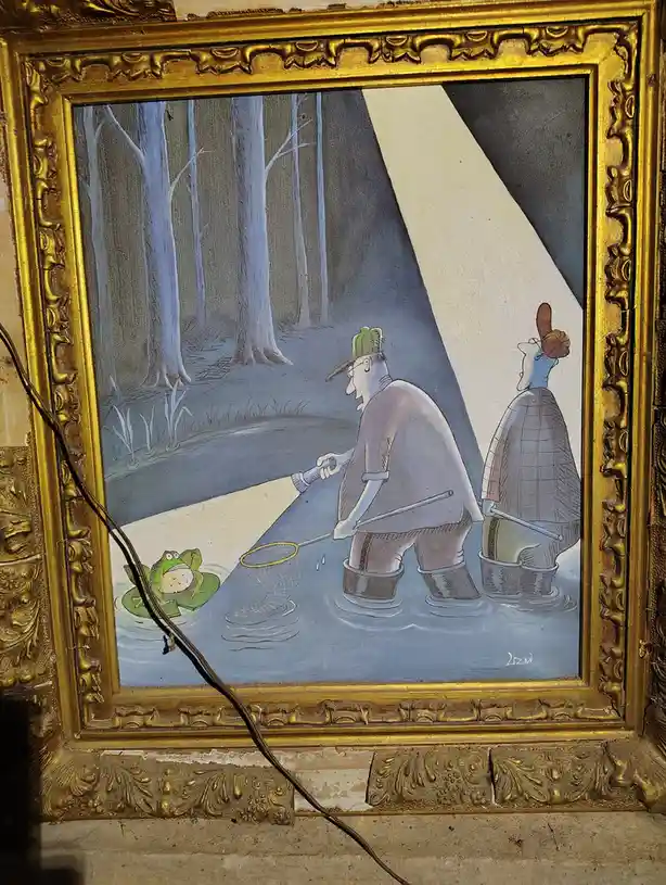 A framed cartoon painting shows two men in waders and hats standing in a pond, shining a flashlight on a frog sitting on a…