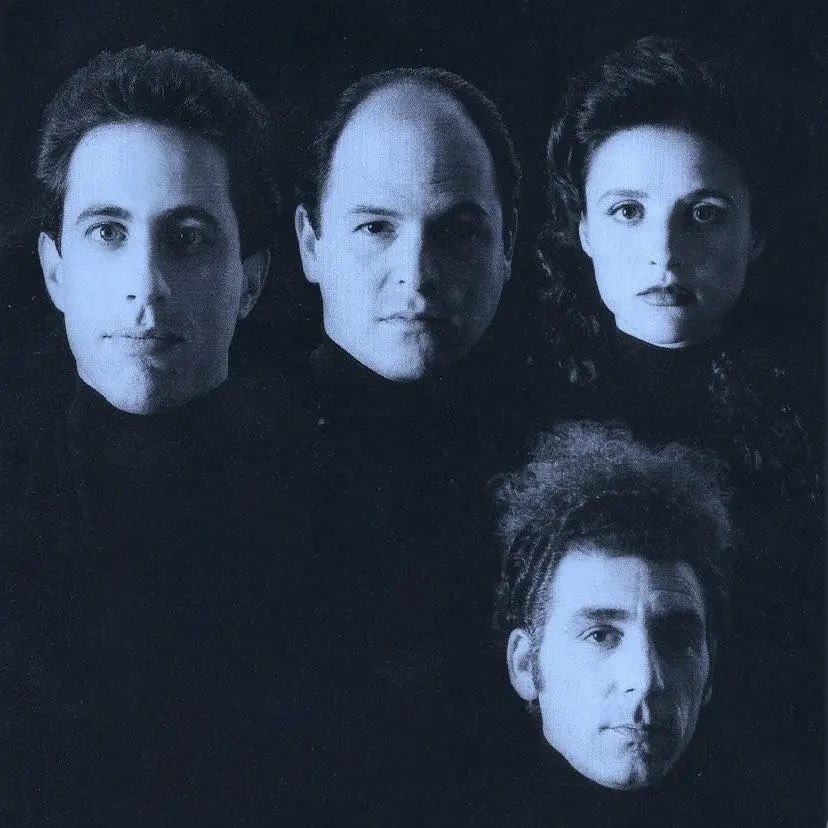 A blue-tinted, dark studio portrait shows four people—three men and one woman—arranged in a row, all looking directly at the…