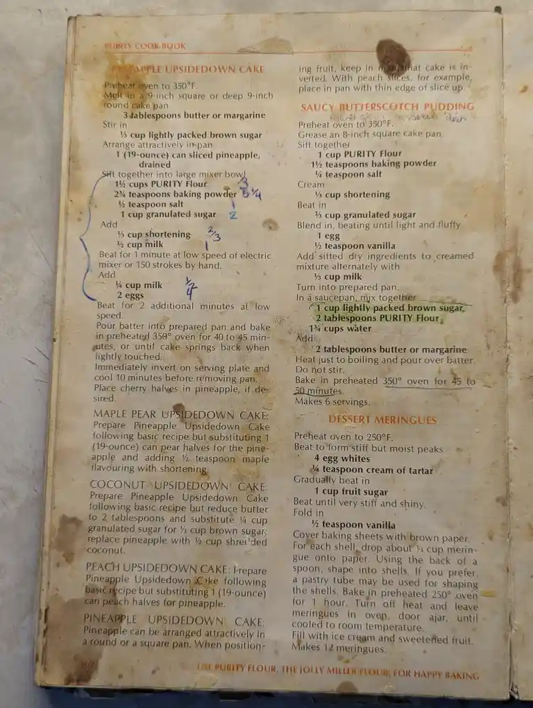 An old, stained page from a 'Purity Cook Book' shows recipes for pineapple upside-down cake and saucy butterscotch pudding…