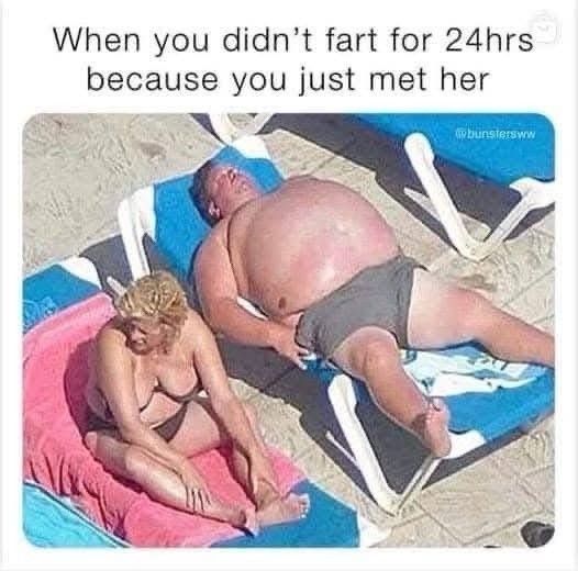 A man and woman are sunbathing on a beach. The man is lying on a blue lounge chair, shirtless and overweight, with his hand…