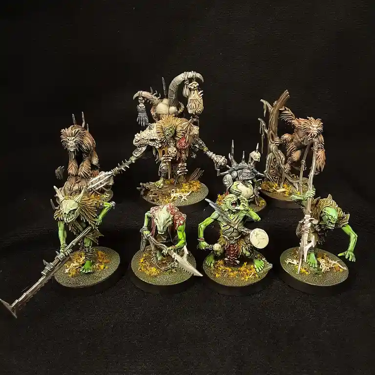 A collection of seven intricately painted fantasy miniatures, resembling grotesque green-skinned orcs and monstrous humanoid…