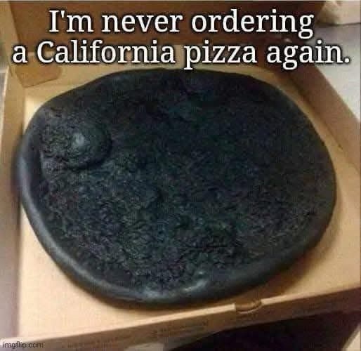A close-up photo shows a pizza in a cardboard box that is completely burnt black, with a single charred bubble on top. The…
