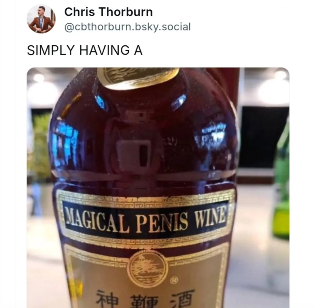 A close-up photo of a dark glass wine bottle with a gold and black label that reads 'MAGICAL PENIS WINE' and Chinese…