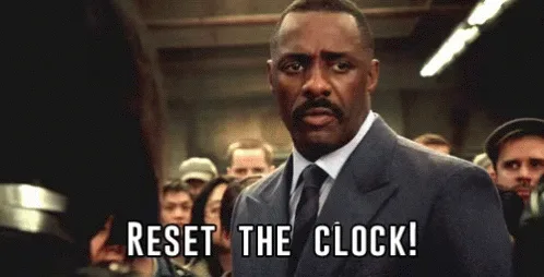 The image shows three panels of actor Idris Elba in a dark suit, standing in front of a crowd in what appears to be a train…