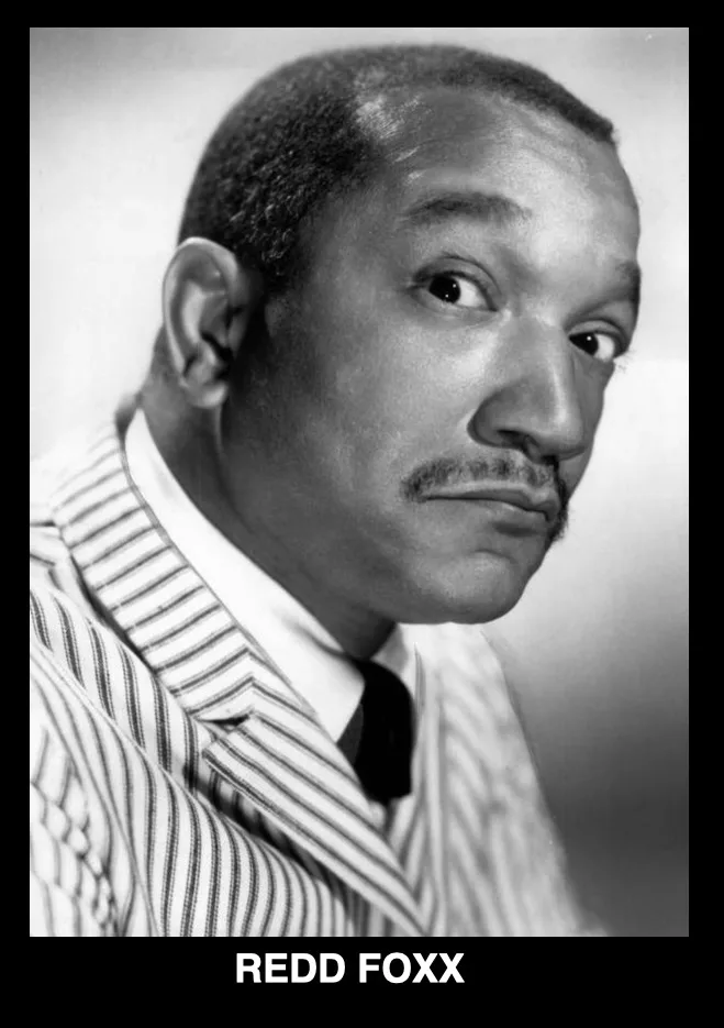 A black-and-white portrait of actor Redd Foxx, who is looking directly at the camera with a slightly raised eyebrow and a…