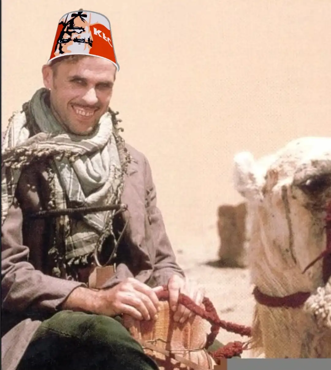 A man in desert attire, smiling while riding a camel, has a KFC bucket superimposed on his head as a fez. The image is a…