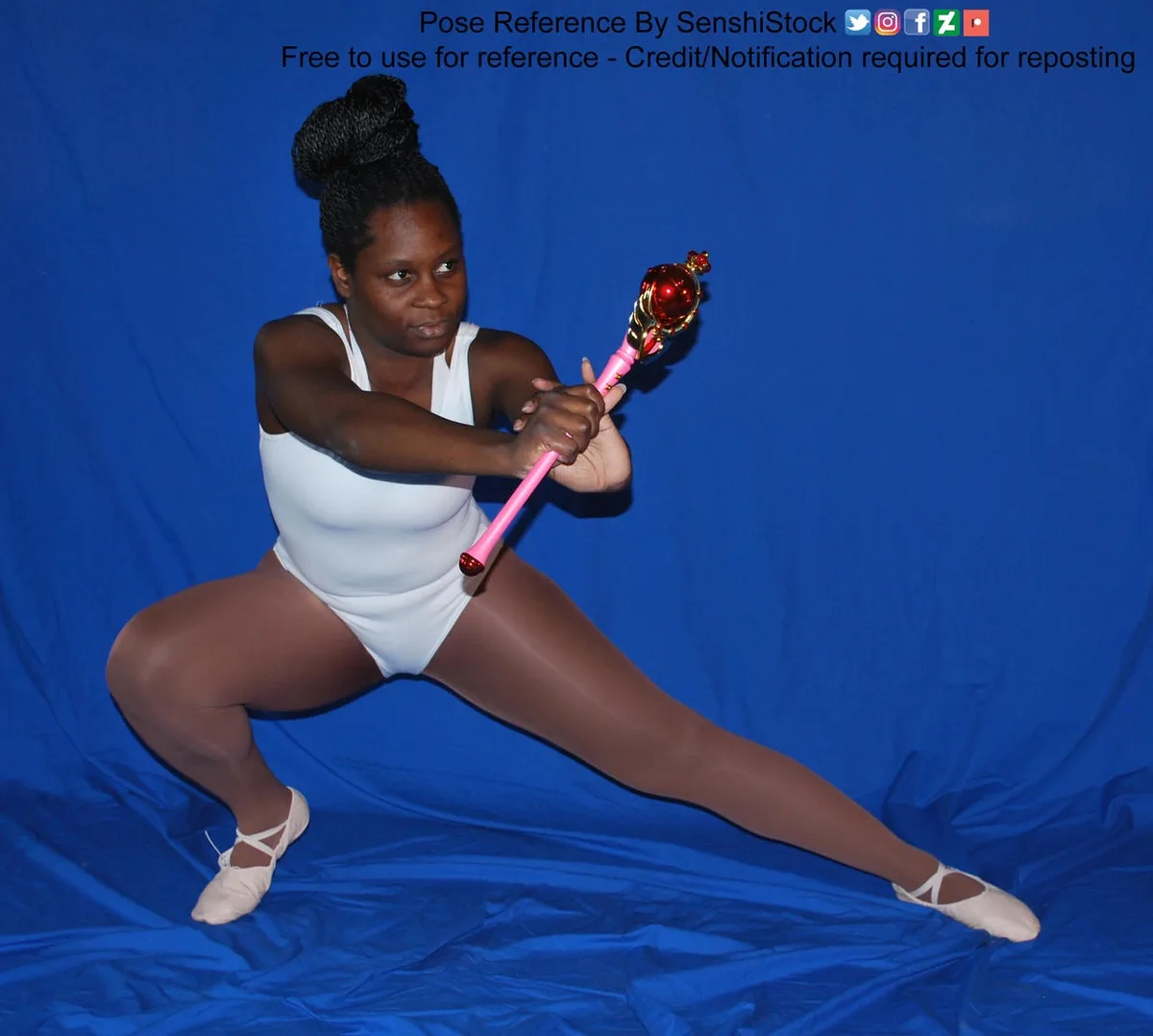 A woman in a white leotard and ballet shoes strikes a dynamic, wide-legged pose while holding a pink and red magical staff…