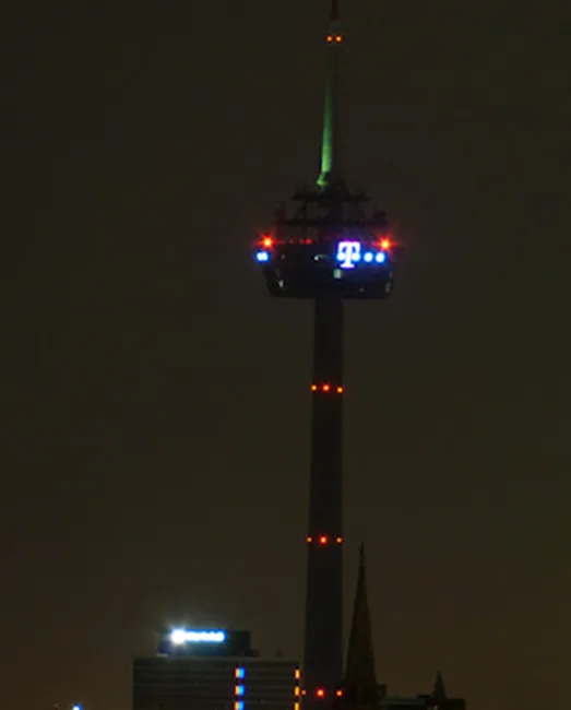 A nighttime photo of the Tower of the Americas in San Antonio, Texas, with its observation deck illuminated by red and blue…