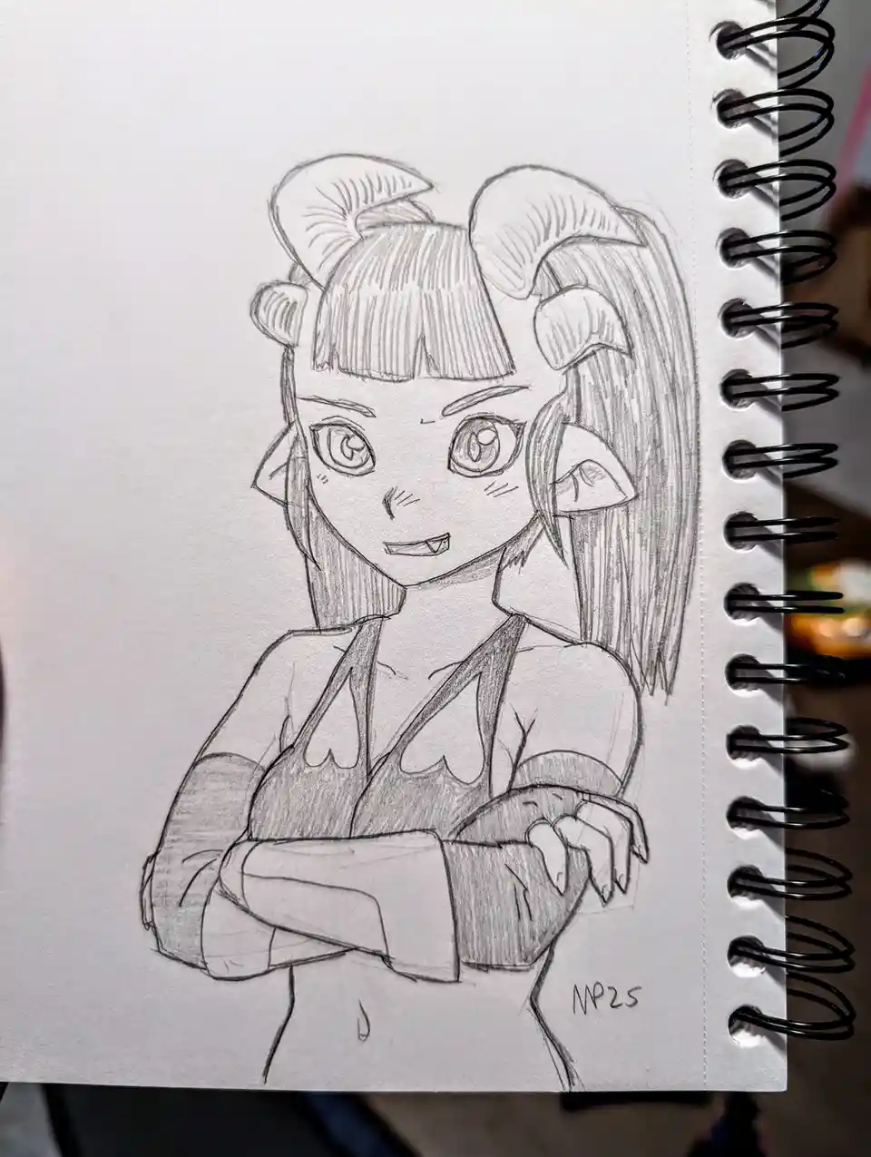 A pencil sketch on spiral-bound notebook paper depicts an anime-style girl with ram horns, pointed ears, and a confident…