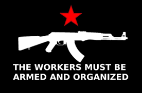 A black background features a white silhouette of an AK-47 rifle centered beneath a red five-pointed star. Below the rifle…