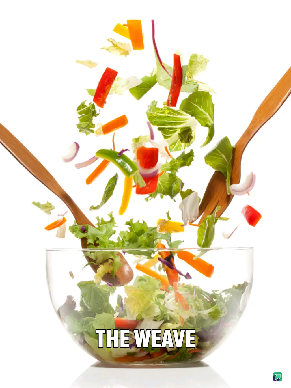 Two wooden salad spoons are shown tossing a vibrant mix of chopped vegetables and greens into a clear glass bowl against a…