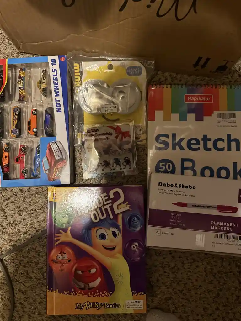 A collection of children's items including a Hot Wheels 10-car set, Minion goggles, a 'Inside Out 2' activity book, a…