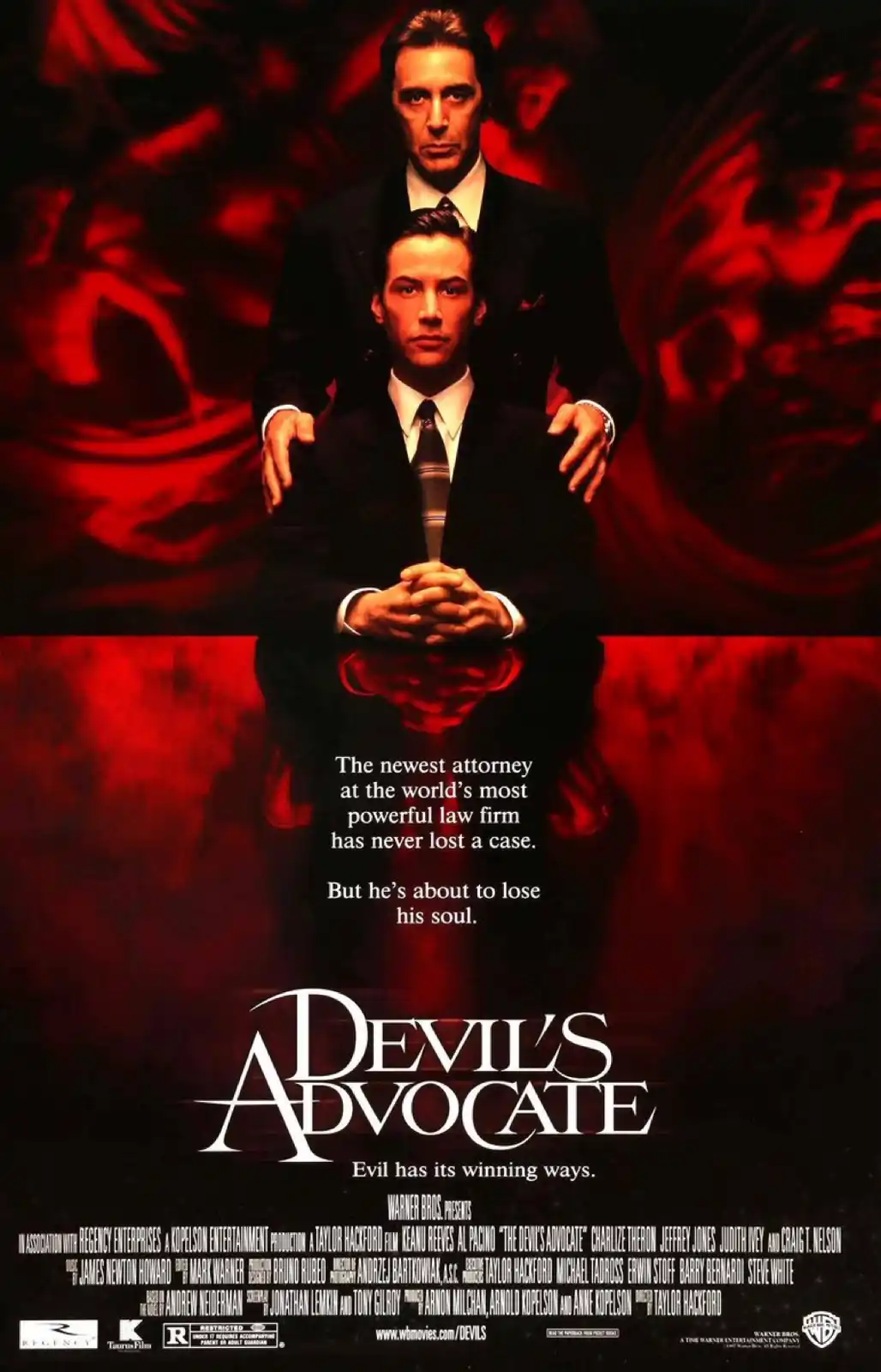 A movie poster for 'Devil's Advocate' featuring two men in suits, one standing behind the other, against a red, swirling…