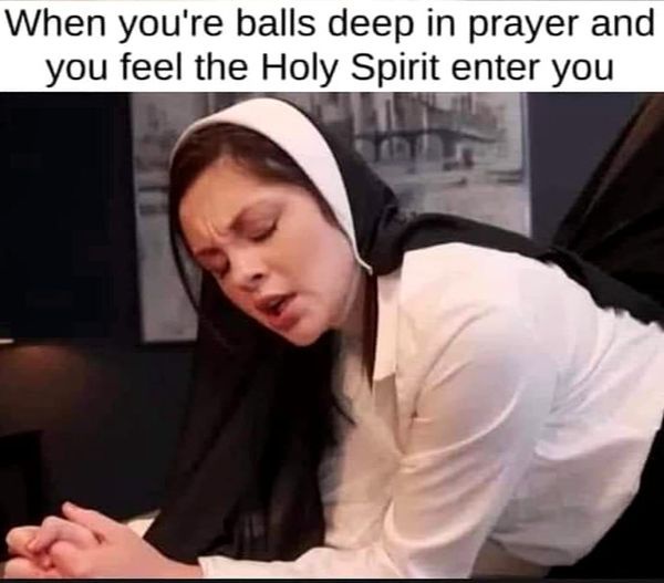 A woman wearing a white shirt and black head covering is bent over with her hands clasped, eyes closed, and face contorted…