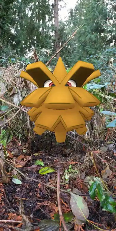 A 3D-rendered yellow Pokémon, resembling a spiky lion-like creature with large eyes, is superimposed onto a real photograph…