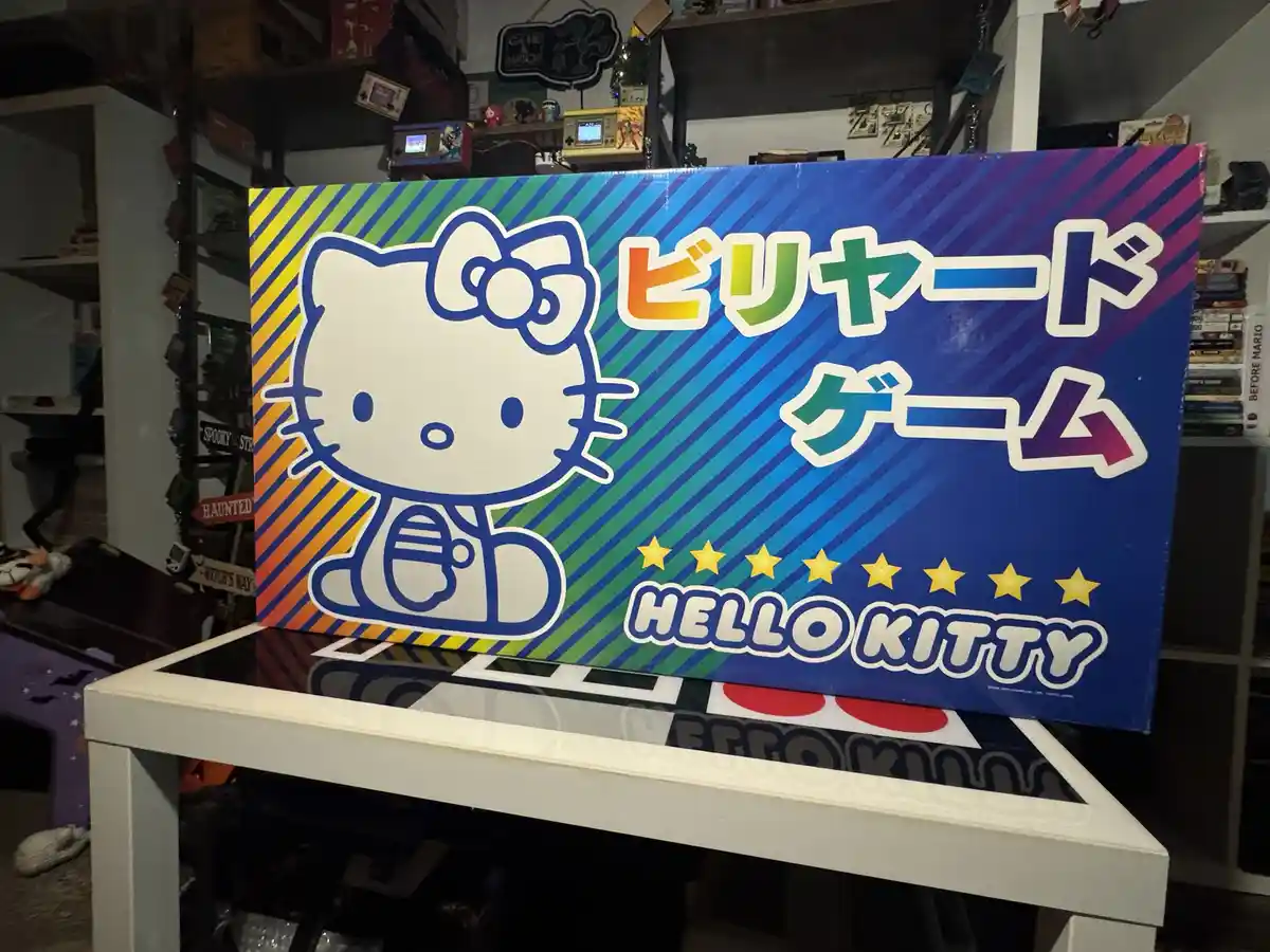 A large, colorful box featuring the Hello Kitty character holding a cue stick, with Japanese text 'ビリヤード ゲーム' (Billiards…