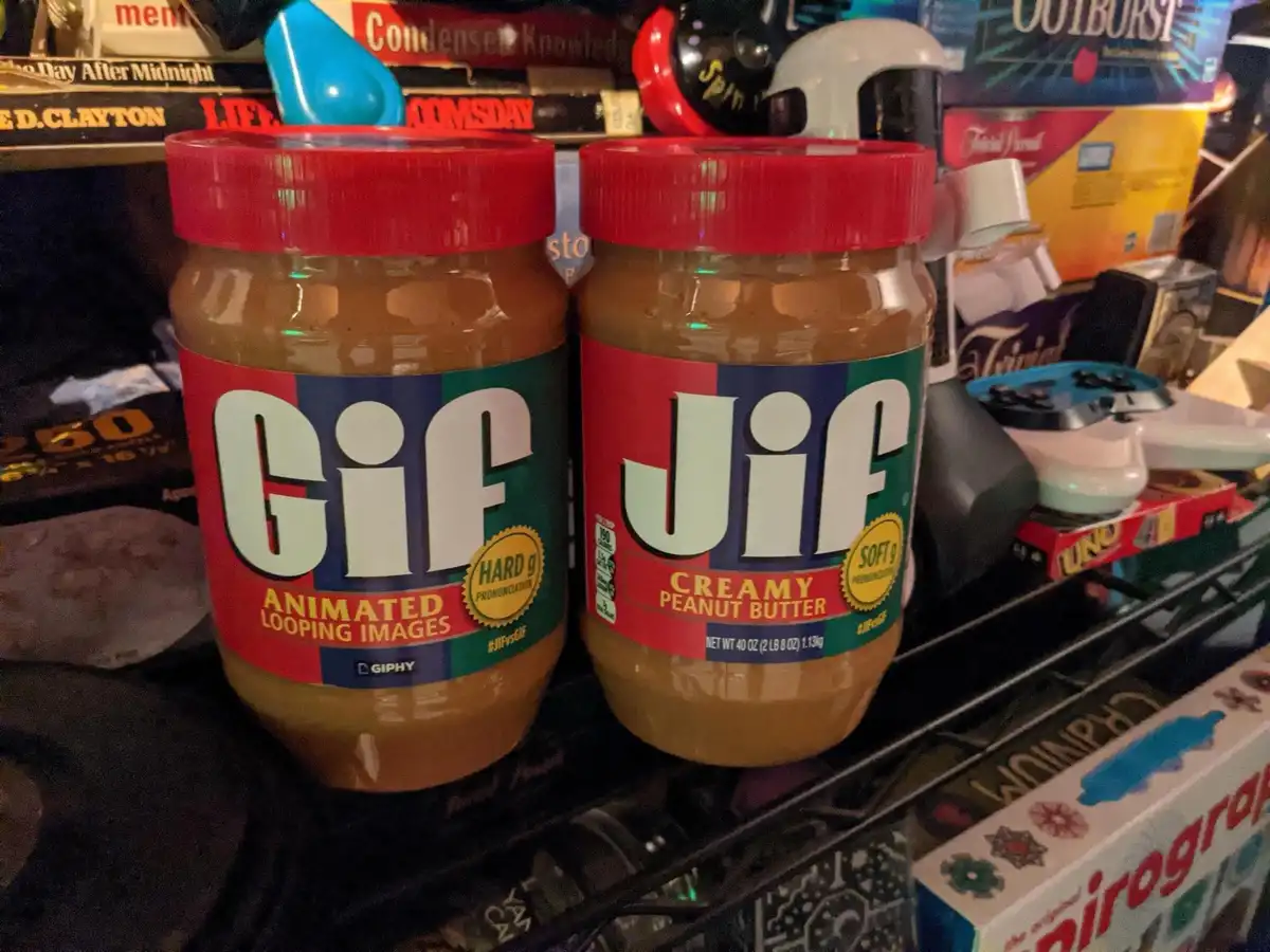 Two jars of peanut butter sit side by side on a shelf, their labels altered to read 'Gif Jif' with 'Gif' on the left jar and…