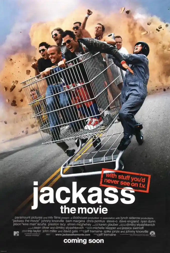 A movie poster for 'Jackass the Movie' shows several men, including Johnny Knoxville, riding in a shopping cart being pushed…