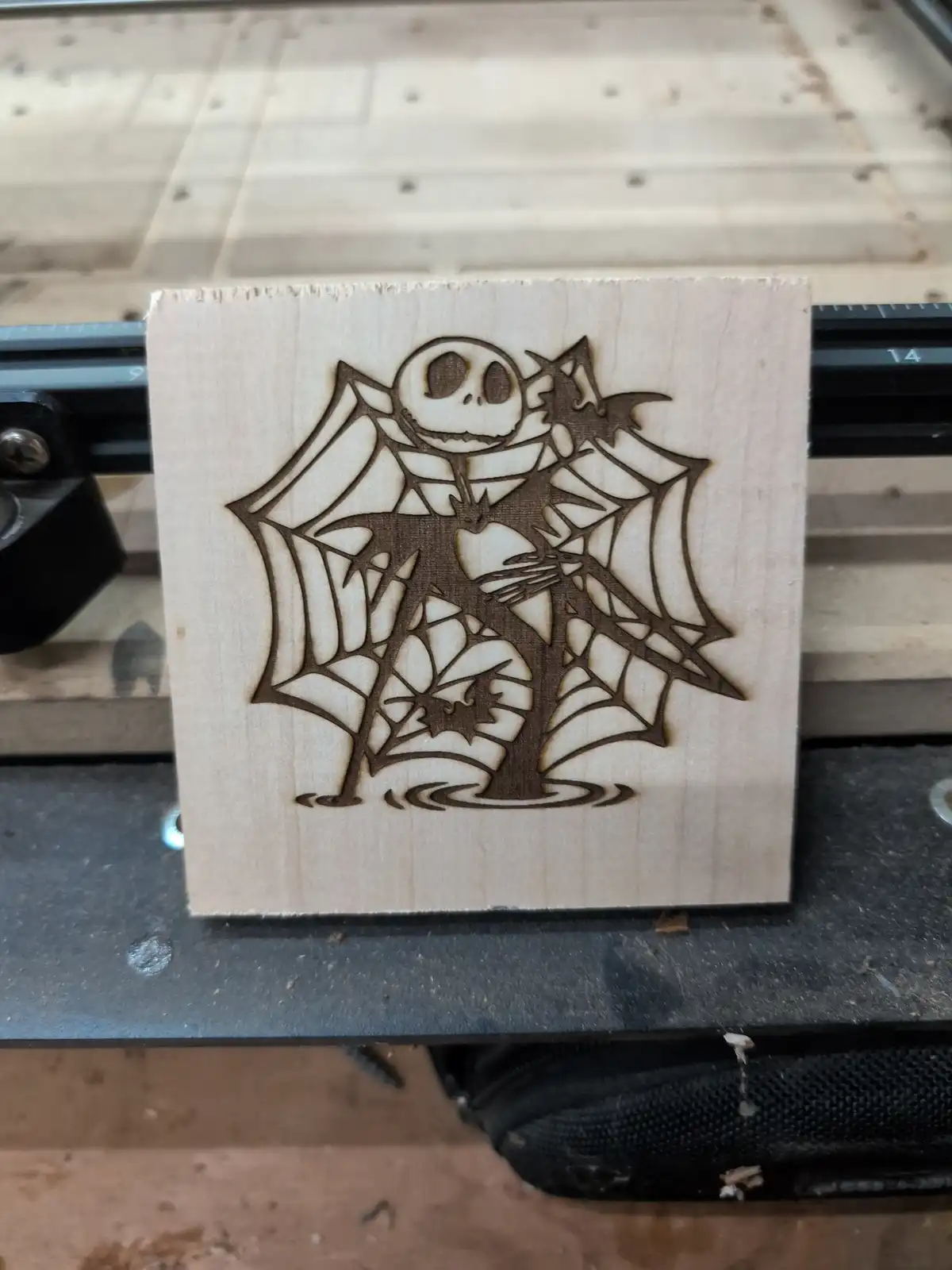 A square piece of light-colored wood with a laser-etched design of Jack Skellington from The Nightmare Before Christmas…