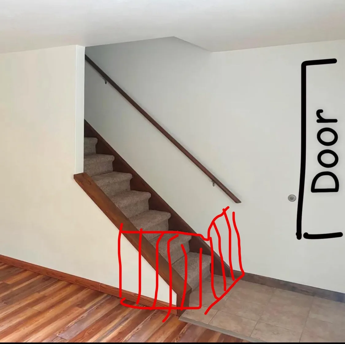 An interior photo of a staircase with carpeted steps and wooden handrail, where a red hand-drawn outline highlights the…