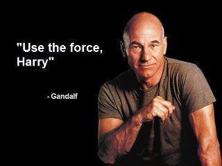 A bald man in a dark t-shirt, resembling Patrick Stewart as Captain Picard, smiles while holding his hand in a gesture…