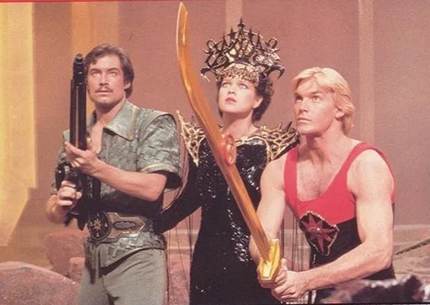 Three characters from the 1980s TV show 'He-Man and the Masters of the Universe' stand side-by-side in a scene. The man on…