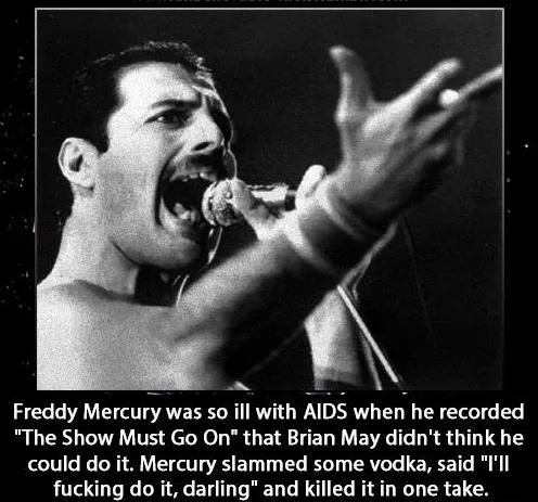A black-and-white photo of Freddie Mercury singing passionately into a microphone, his mouth wide open and one hand raised…