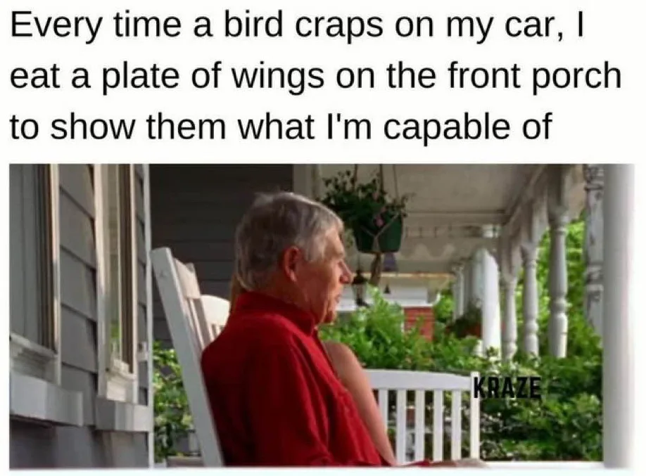 An older man with gray hair sits in a white porch chair, wearing a red shirt, looking off to the side. The image has black…
