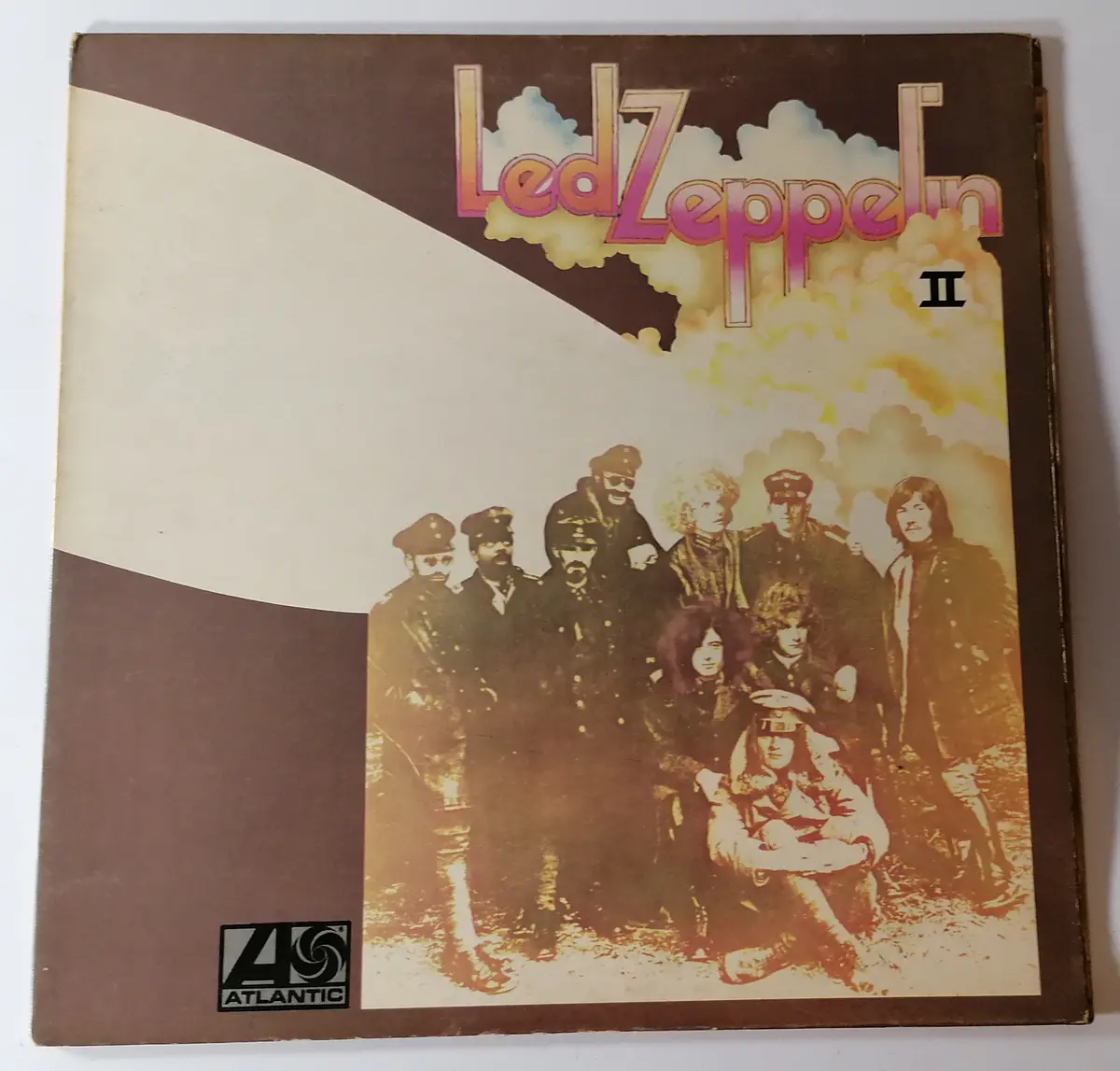 The image shows the cover of the Led Zeppelin II vinyl record album, featuring the band members in military-style uniforms…