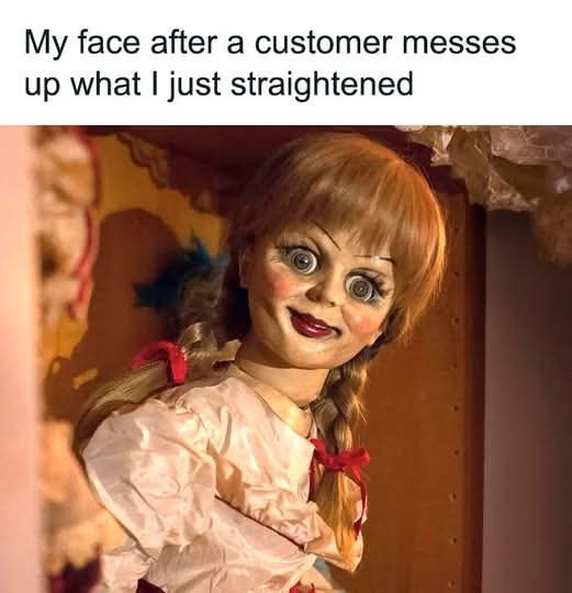 A close-up of the doll Annabelle from the horror franchise, showing her wide, startled eyes and slightly open mouth. She…