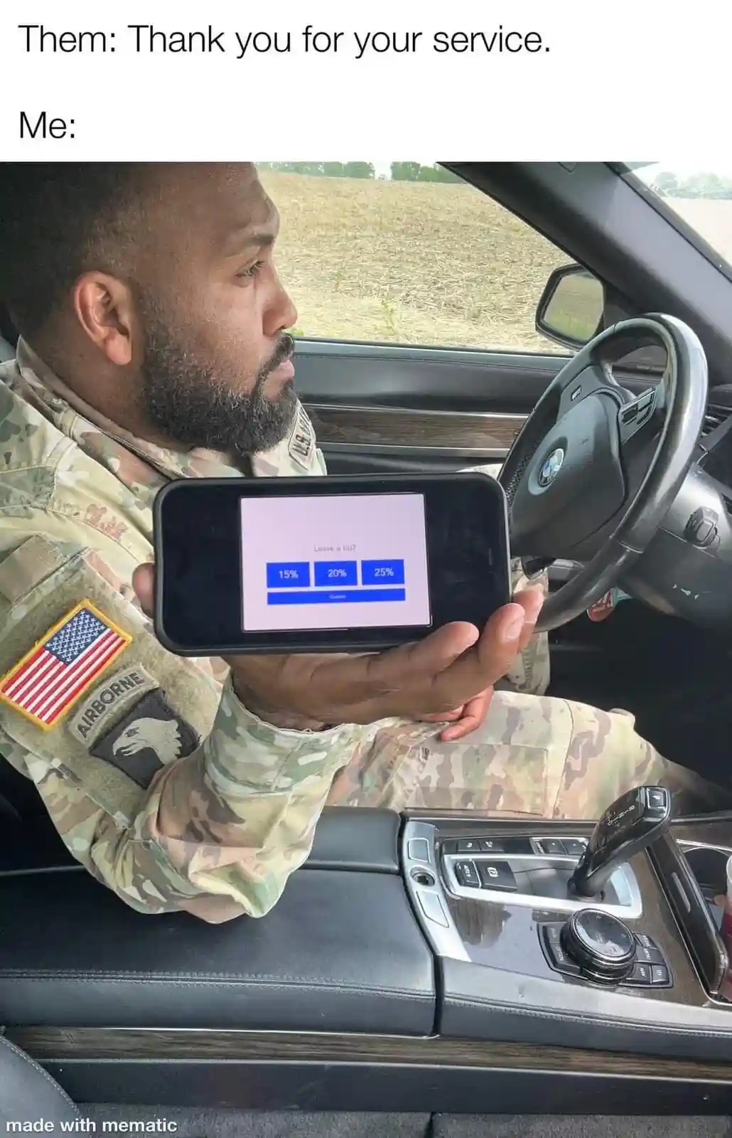 A man in military camouflage uniform, identified by an 'AIRBORNE' patch and American flag, sits in the driver's seat of a…