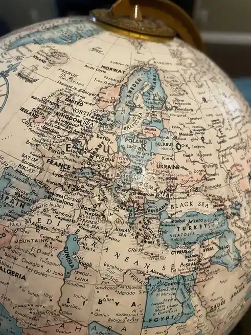 A close-up photo of a vintage-style globe showing Europe and the Middle East, with countries like Ukraine, Turkey, and Egypt…