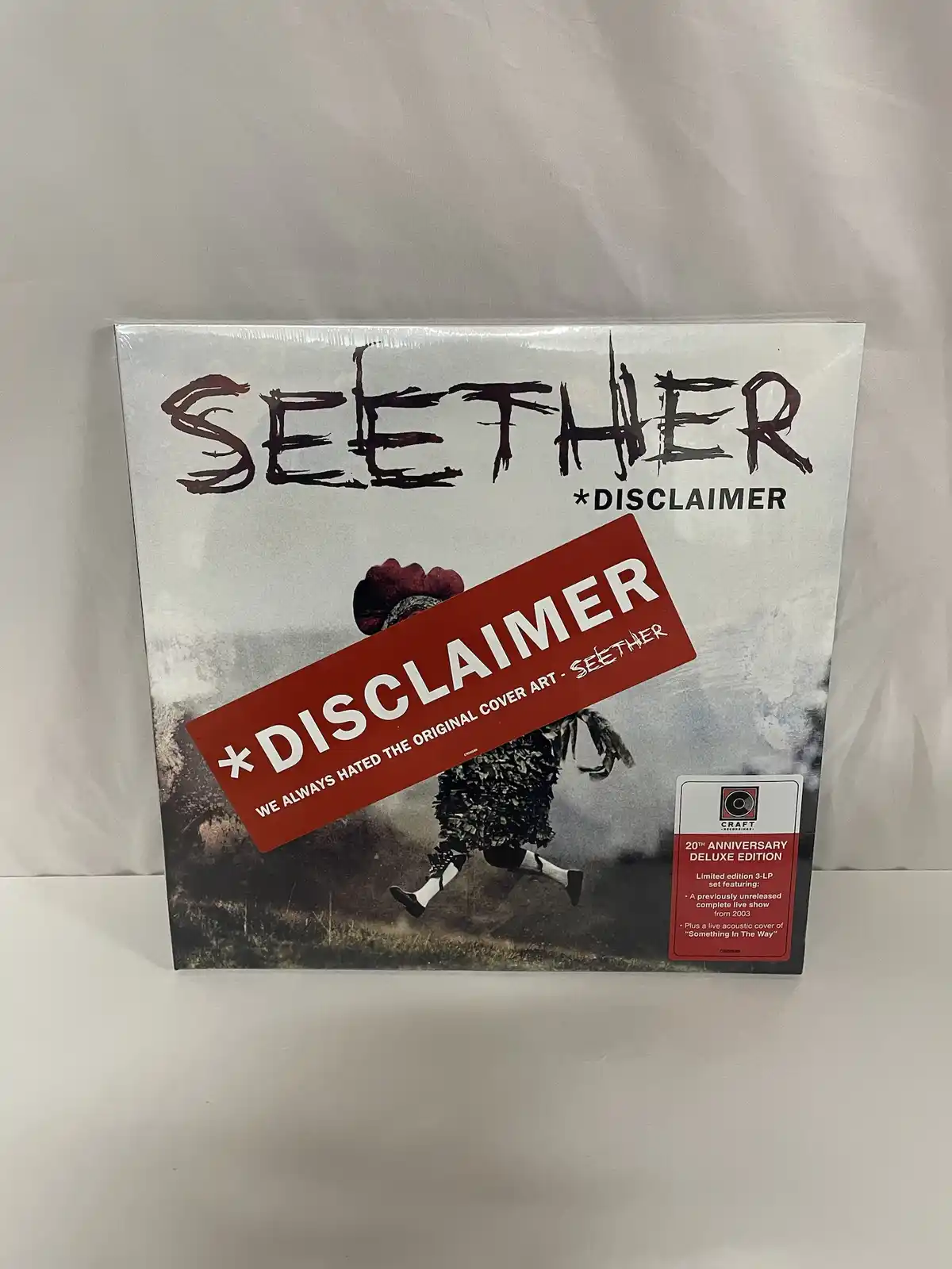 A Seether album cover for 'Disclaimer' is shown with a large red disclaimer sticker overlaid on the image, stating 'WE…