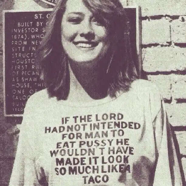 A woman with shoulder-length hair smiles while wearing a white t-shirt with bold black text that reads: 'IF THE LORD HAD NOT…