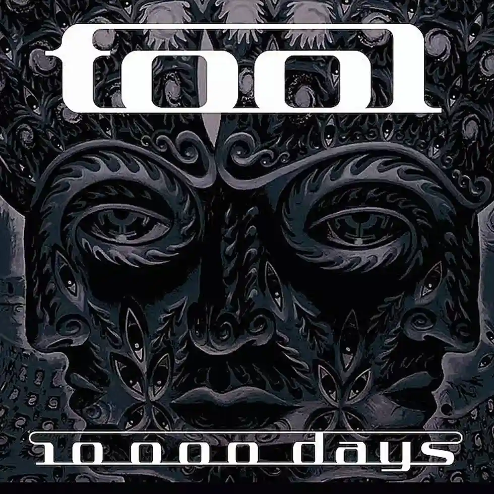The image displays the album cover for Tool's '10,000 Days', featuring a dark, intricate, stylized face with multiple eyes…