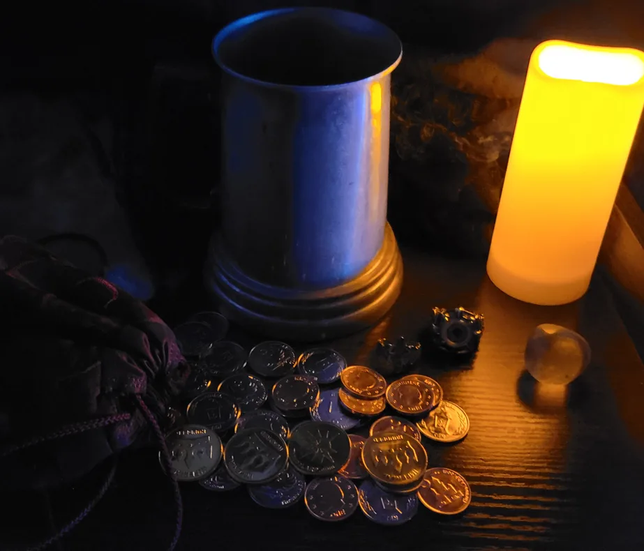 A dimly lit table holds mystical items: a glowing candle, a metal chalice, scattered coins (some gold, some silver), a…