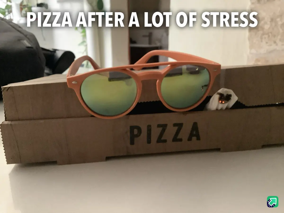 A cardboard pizza box with the word 'PIZZA' printed on it sits on a white surface. Resting on top of the box are a pair of…