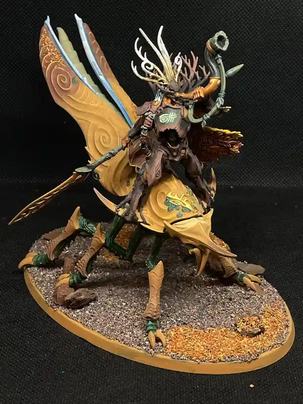 A highly detailed, painted fantasy miniature depicts a monstrous, insectoid rider with large, ornate wings and antlers…