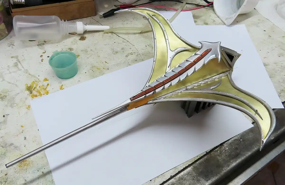 A highly ornate, custom-made sword with a silver and gold finish, featuring intricate designs and a long, slender blade…