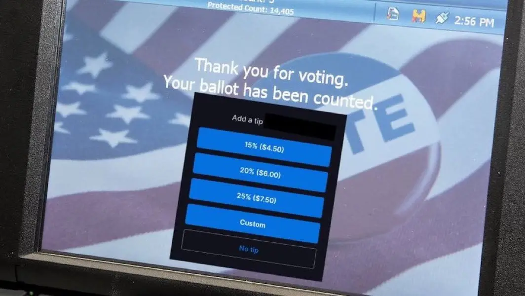A computer screen displays a voting confirmation message 'Thank you for voting. Your ballot has been counted.' overlaid with…