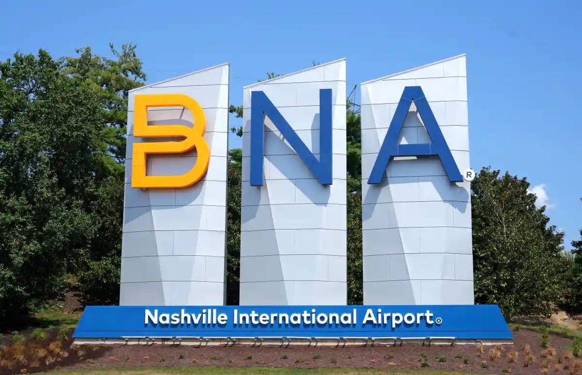 A large outdoor sign for Nashville International Airport displays the letters 'BNA' in bold, three-dimensional font on white…