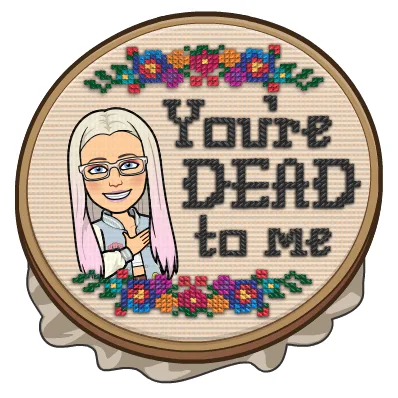 A circular embroidery hoop displays a pixelated cartoon woman with long pink and white hair and glasses, smiling while…