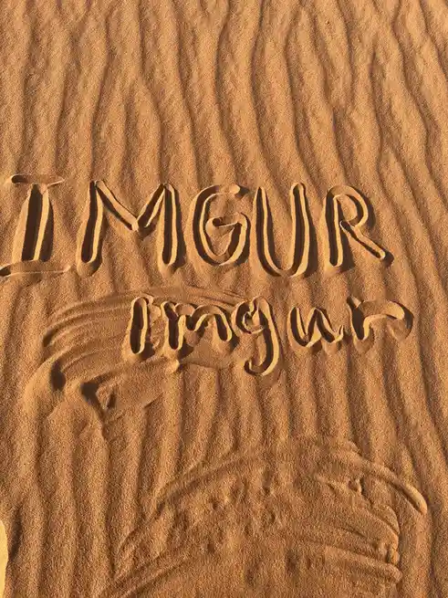 The image shows the word 'IMGUR' carved in uppercase letters into sand, with the word 'imgur' written below it in lowercase…