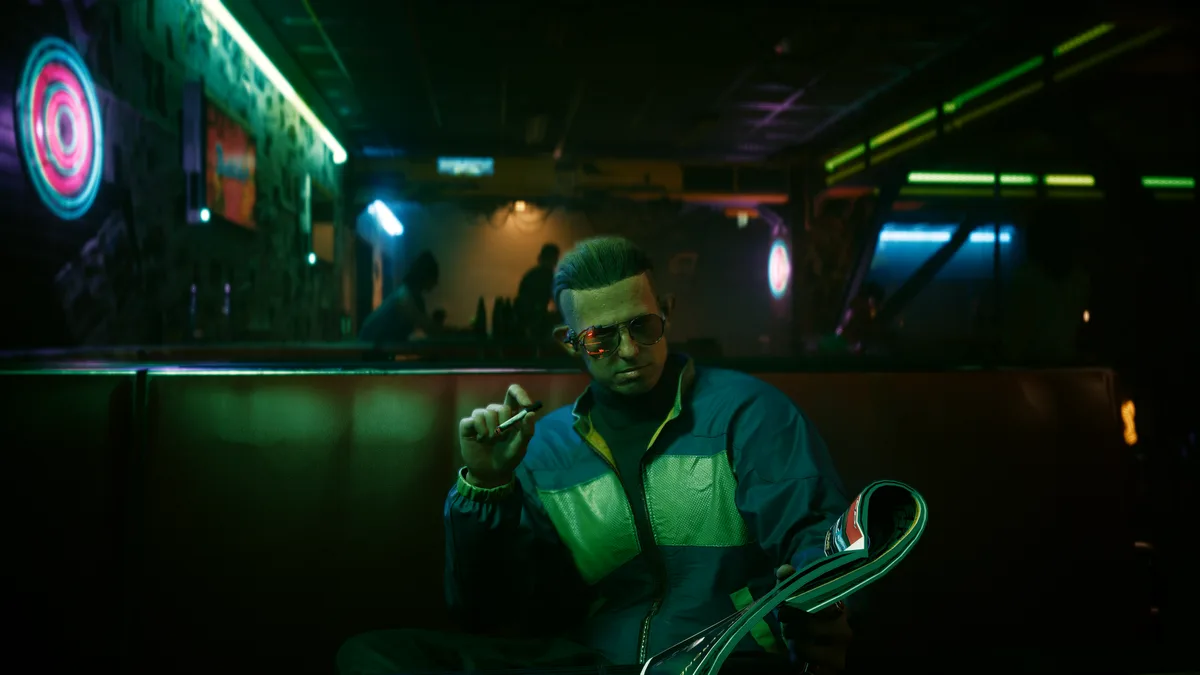 A man in a retro-futuristic neon-lit bar, wearing aviator sunglasses and a blue-green jacket, holds a cigarette in one hand…
